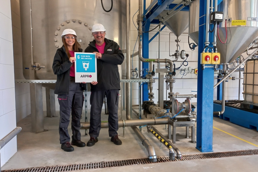 Two JSP employees holding the UN SGD goal - Water Stewardship icon