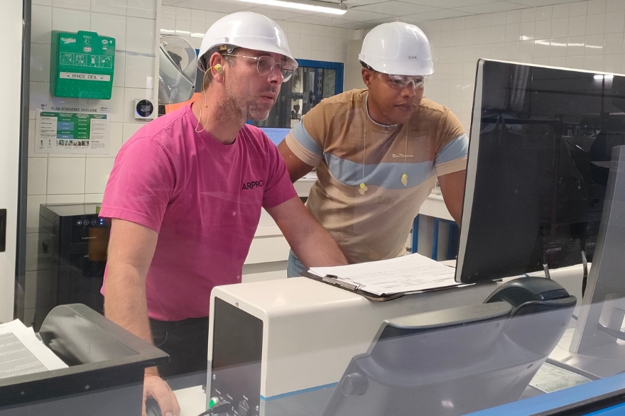 Due uomini in laboratorio JSP che controllano un computer per la gestione qualità.