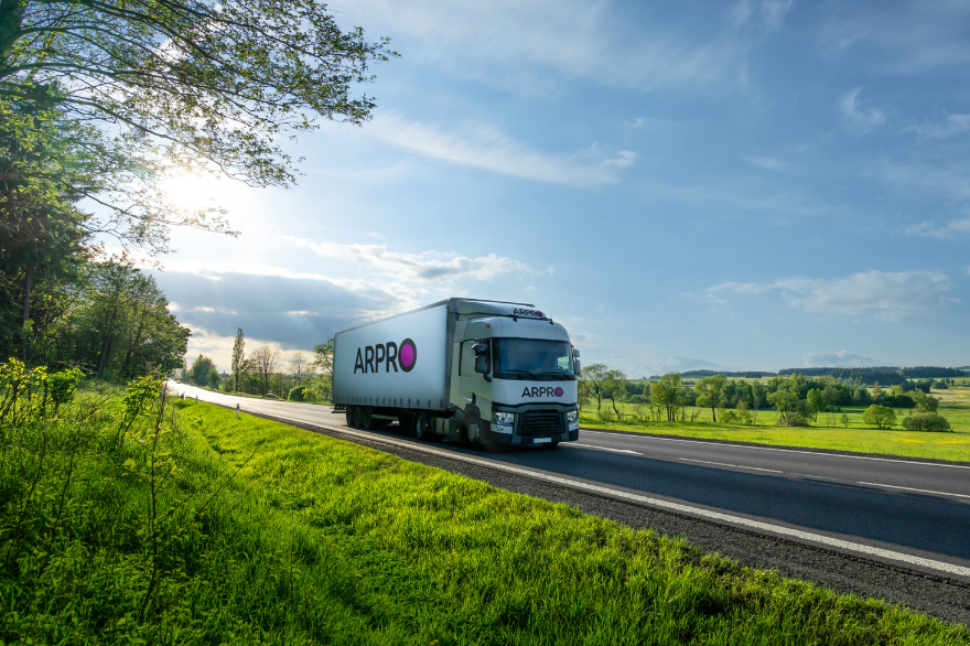 A white truck with an ARPRO logo driving through green countryside