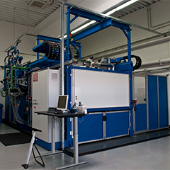 Blue and white industrial machine with chair, table and computer