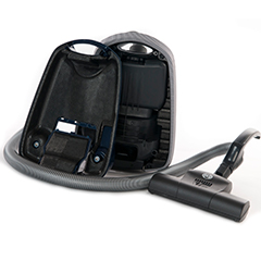Dark blue small sebo vacuum cleaner, opened to show ARPRO (expanded polypropylene) inside, with hose wrapped around it 